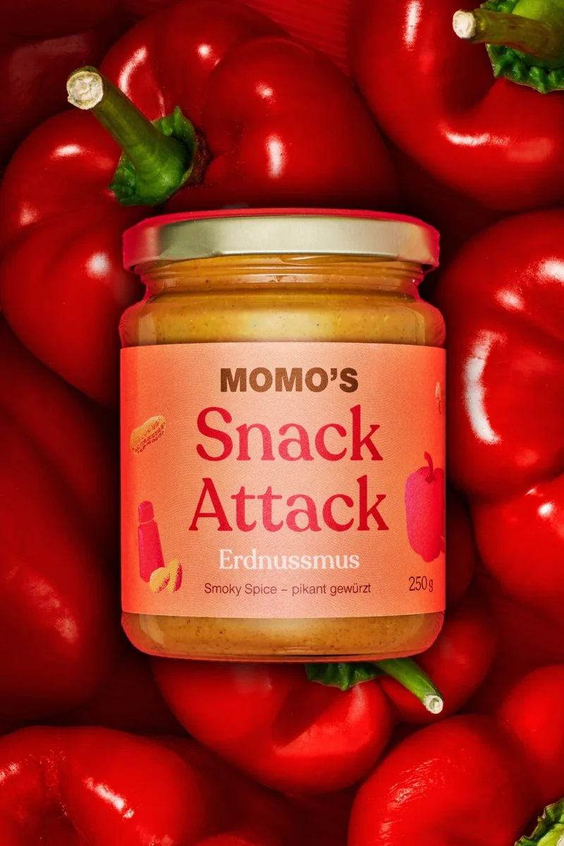 Erdnusscreme zwischen glänzenden roten Paprika