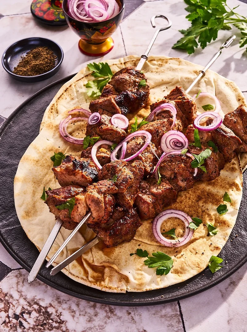Schaschlik auf Fladenbrot mit roten Zwiebeln