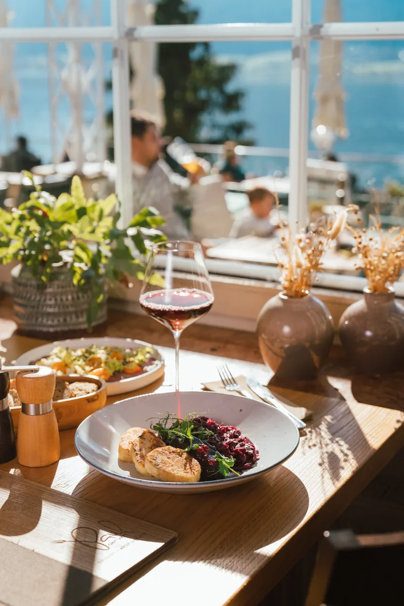 Sonniger Tisch mit Speisen und Wein bei Paul