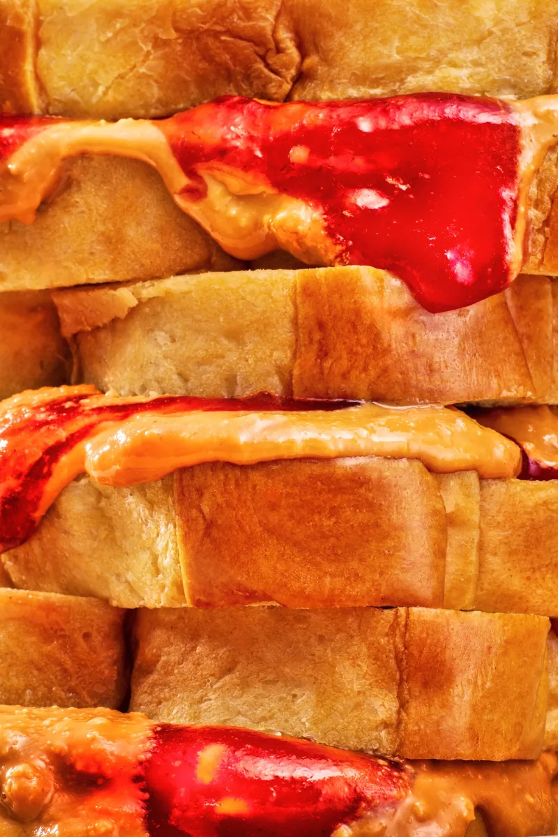 Stack of toast with peanut butter and red jam