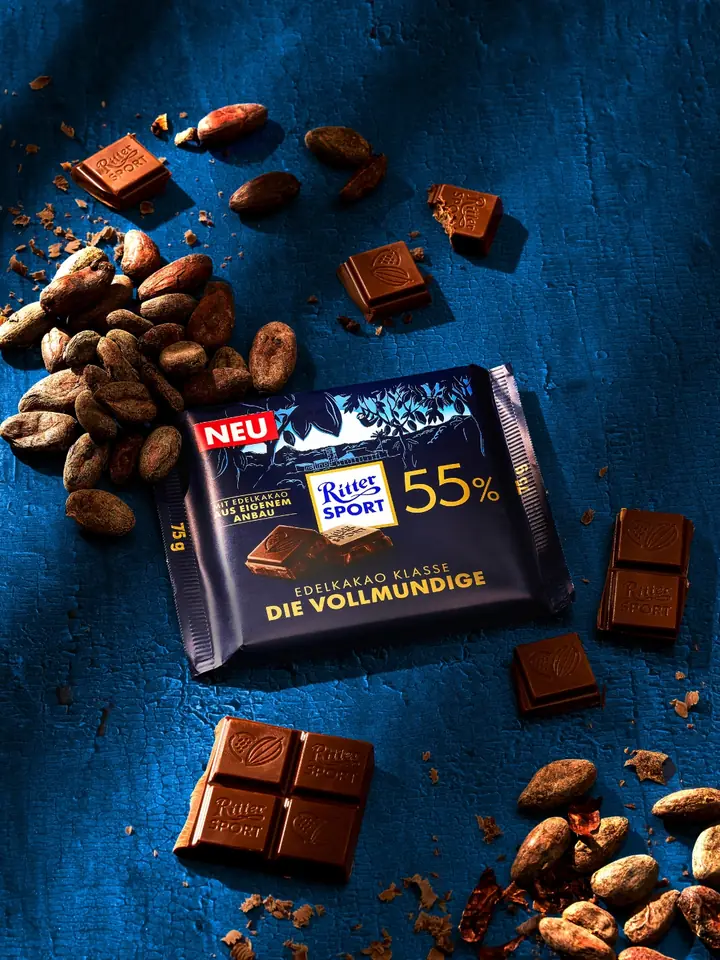 Ritter Sport Edelkakao Klasse mit Kakaobohnen auf blauem Grund
